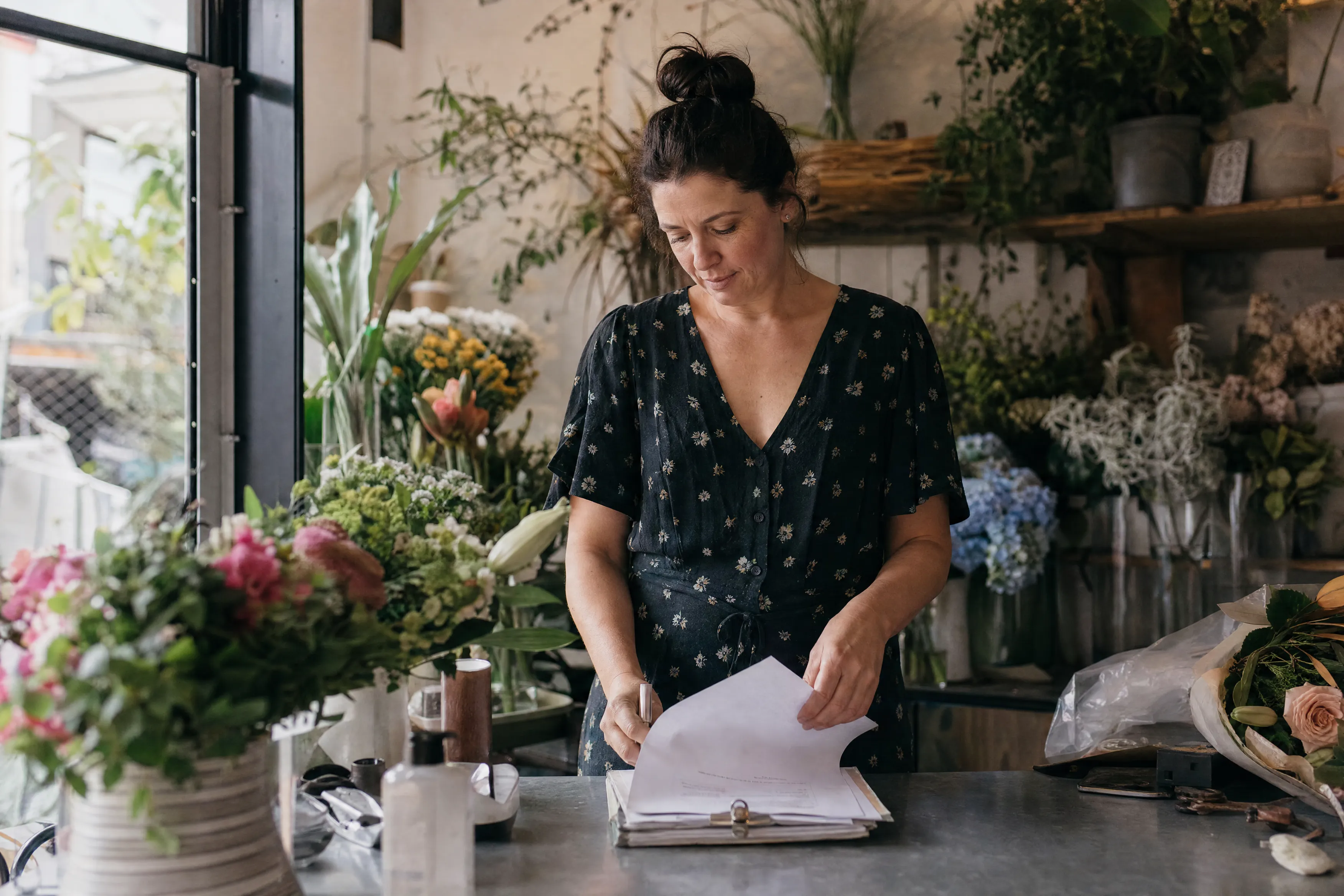 Owner organising paperwork in her florist shop
