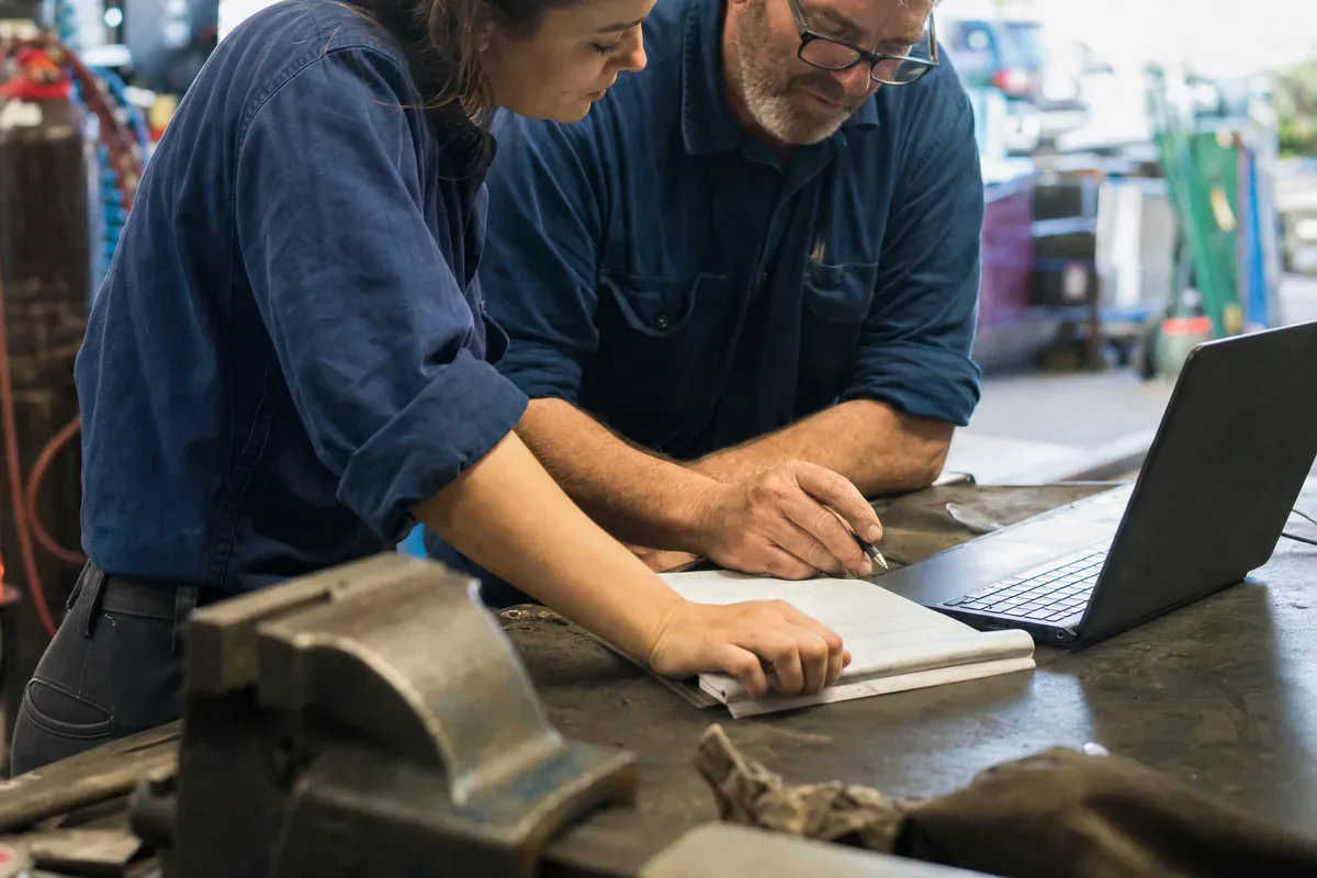 Two workshop owners going over their figures together